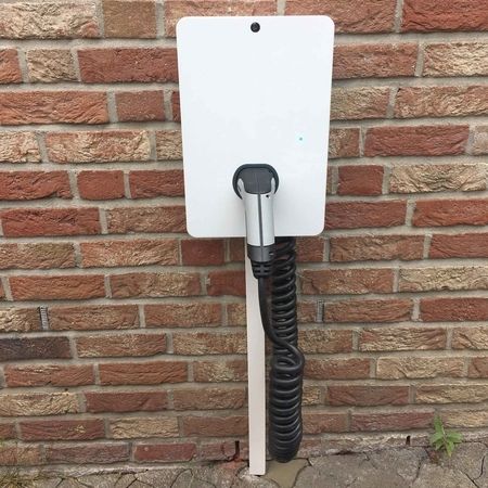 Ladestation für Elektrofahrzeuge an einer Backsteinmauer.