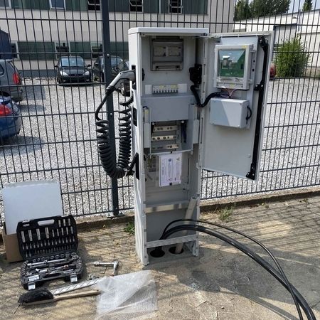 Eine offene elektrische Ladestation mit Werkzeugen auf dem Boden.