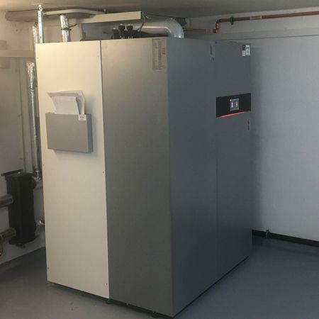 Großer grauer Industrieschrank in einem Hauswirtschaftsraum mit Rohren über dem Kopf.